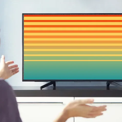 Television displaying colorful vertical and horizontal lines, indicating a faulty T-Con board fixed by OnePlus TV repair in Hyderabad.